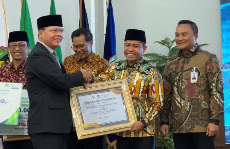 Bupati Lebong Kopli Ansori saat menerima piagam penghargaan Paritrana Award yang diserahkan Gubernur Bengkulu Rohidin Mersyah, Rabu (1/3/2023) 